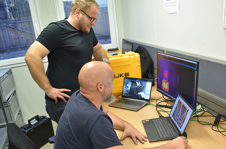 GTL Gründer Max Hofer und Mitarbeiter Florian schauen in Bildschirm und zwei Notebooks in Kontrollraum der GTL