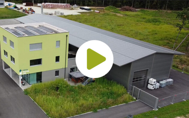 Mit Drohne aufgenommenes Bild des grünen würfelförmigen Gebäudes der Green Testing Lab mit Testgelände und 
